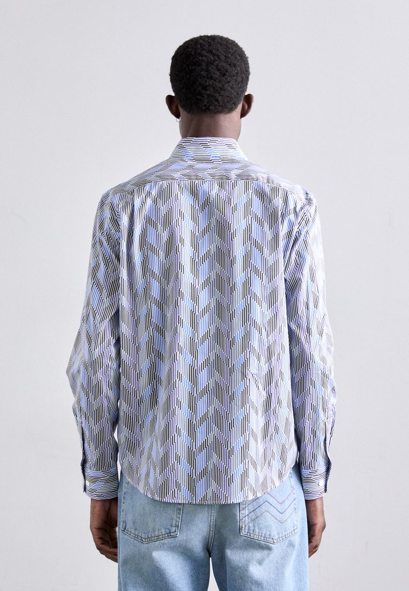 Langærmet skjorte med et lysblåt og hvidt zigzag-mønster, skjortekrave med knapper og kontrasterende striber ved manchetter og kant.