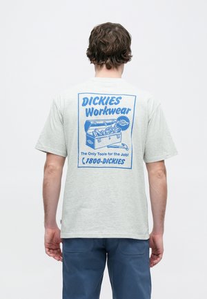 Helehall hall puuvillane t-särk, millel on sinine graafiline kujundus seljal, kujutades tööriistakasti ja tekst "DICKIES Workwear". Lühikesed varrukad.