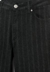Jeans in denim nero con un classico design a cinque tasche, chiusura con bottone metallico e sottili dettagli testurizzati verticali.