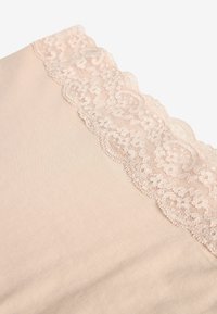 Nud färgad tyg med delikat rosa spetskant längs den övre kanten, med en vågig design och blommönster, slät textur.