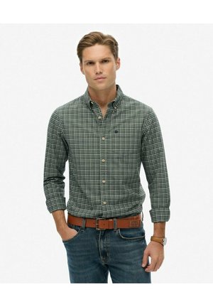 Groene geruite shirt met knoopkoordkraag, lange mouwen en contrasterende knopen, gecombineerd met donkerblauwe jeans en een brown leren riem.
