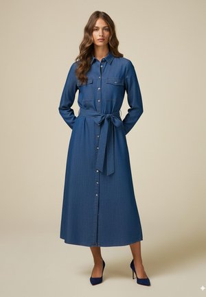 Vestido de camisa de denim, de manga larga, con botones en la parte delantera, cintura ceñida con un lazo y dos bolsillos en el pecho. Color azul oscuro y textura suave.