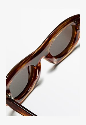 Bruna sköldpaddsolglasögon med rundade glas, mörka linser och en glansig finish, som visar upp tjocka, kurviga stänger och minimal hårdvara.