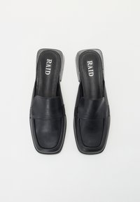Zwarte leren instap schoenen met een vierkante neus en een lage, transparante hak. De binnenzool is voorzien van de mernaam "RAID" in het wit.