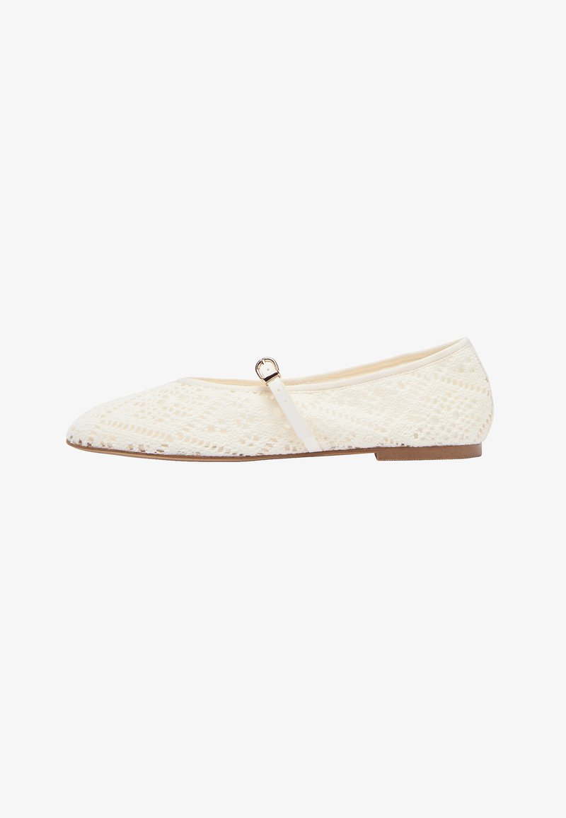Chaussure plate Mary Jane couleur crème avec un motif en dentelle complexe et une petite boucle dorée sur la bride, semelle marron, vue de côté.