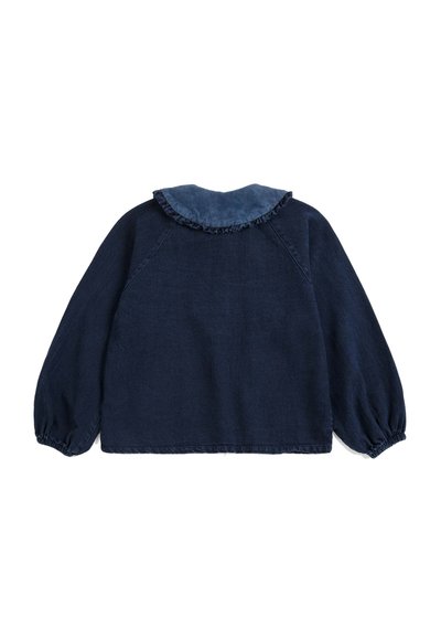 Chemise bleu marine à manches longues avec poignets élastiques et un col à volants dans un tissu bleu un peu plus clair.
