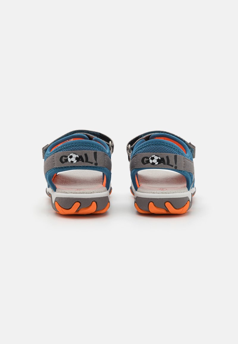 Blaue und graue Sportsandalen mit verstellbaren Riemen, orangefarbenen Akzenten auf der Sohle, strukturiertem Fußbett und einem "GOAL!"-Logo auf dem Riemen.