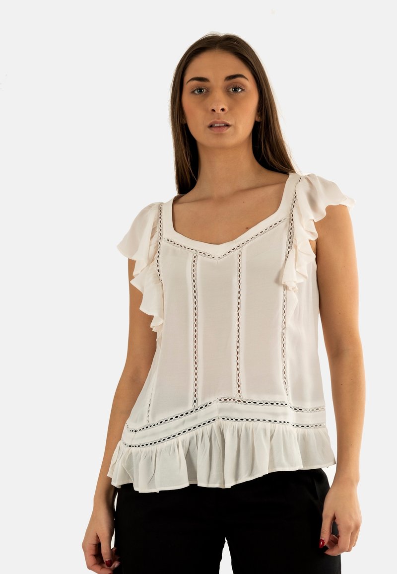 Chemisier blanc avec des manches froncées, descoutures décoratives, un décolleté en V et un ourlet évasé. Fabriqué en tissu léger.