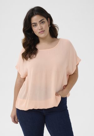 Peach-colored, loose-fitting blouse with short sleeves and a rounded neckline in a lightweight, textured fabric.