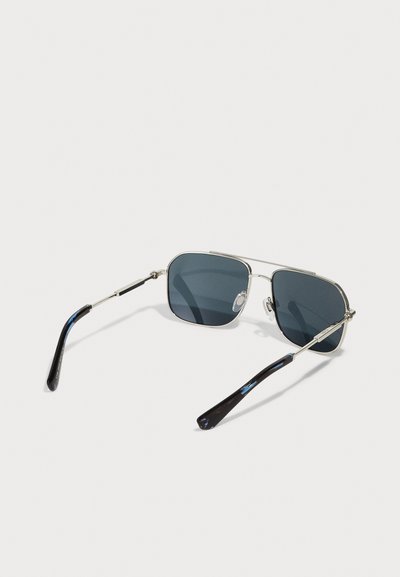 Metallic aviator sunglasses with dark lenses, featuring a double bridge and textured black tips on arms.