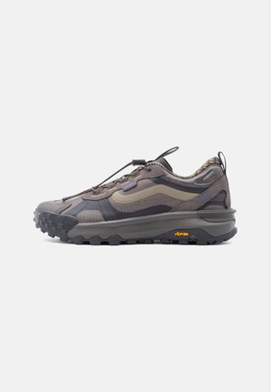 Low-profile gray and beige trail sneaker with textured Vibram sole, lace toggle, and pull tabs at tongue and heel.