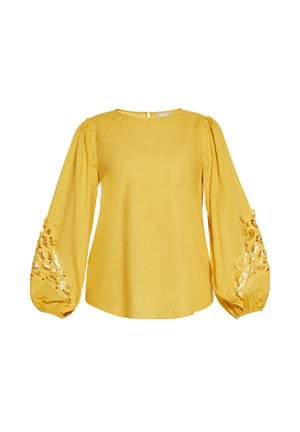 Geel blouse van lichte stof; heeft lange pofmouwen met kant uitsnijdingen bij de manchetten; ronde halslijn, met een keyhole-sluiting op de rug.