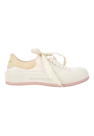 Biały niski sneaker z beżowym zamszowym obcasem, teksturowaną gumową podeszwą i sznurowadłami w stylu wstążki, oznaczenie Alexander McQueen po boku podeszwy.