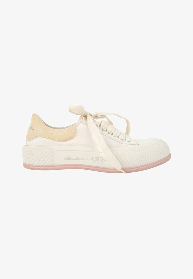 Baskets basses blanches avec talon en daim beige, semelle extérieure en caoutchouc texturé et lacets style ruban, marquage Alexander McQueen sur le côté de la semelle.