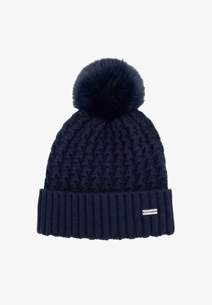 Navy knitted beanie with a chunky pattern, a ribbed cuff, and a large fluffy pom-pom on top. Features a small brand label on the cuff.