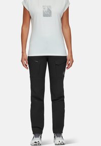 Svarta utomhusbyxor med flera fickor, en åtsittande design och förstärkt sömnad. Bärs med en vit grafisk T-shirt och slitstarka skor.