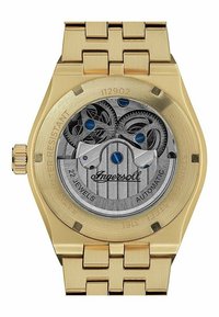 Goldfarbene automatische Uhr mit einem Edelstahlarmband. Der transparente Gehäuseboden zeigt komplizierte silberne Zahnräder und blaue Akzente.