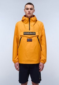 Yellow waterproof jacket with a front pocket, half-zip, and a logo patch. Features a small Norway flag detail and adjustable drawstring hood.