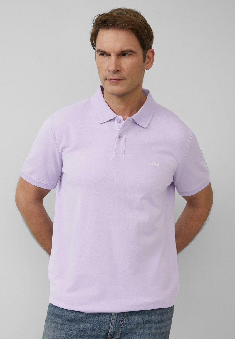 Lichtpaarse polo met een klassieke kraag, korte mouwen en een subtiele logo op de borst. Gemaakt van een gladde, gestructureerde stof.