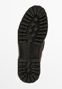 Suola di una scarpa nera in gomma con tacchetti profondi, motivi di presa a forma di fiore e la scritta "Massimo Dutti 42 Comfort Light" impressa nell'area del tallone.