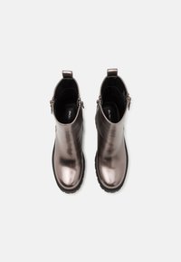 Botas de tobillo plateadas metálicas con una textura suave, punta redondeada, tacón bajo y cremalleras laterales para un fácil uso. Suelas de goma gruesas para mayor durabilidad.