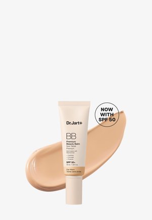 Tube de Dr. Jart+ BB Premium Beauty Balm avec SPF 50, teinte Fair Warm, sur une trace de crème fond de teint beige.