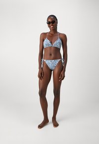 Bikini-set i blå paisleymønster. Toppen har en trekantet fasong med tynne stropper. Bikinitrusa har knytet sider og lav skjæring. Teksturert stoff.