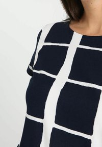 Námořnická blůza s bílým mřížkovým vzorem, kulatým výstřihem, krátkými rukávy a měkkou látkou s hladkým povrchem.