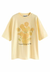 Vaaleankeltainen lyhythihainen T-paita, jossa on auringonkukkavaasi -painatus ja teksti "Tournesols, Vincent Van Gogh" edessä.