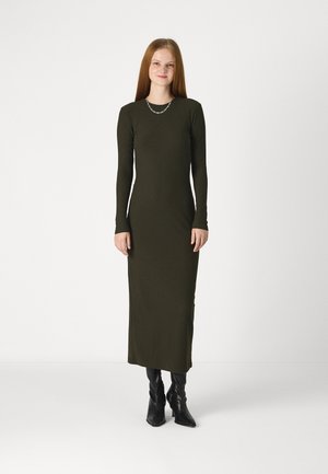 Long-sleeve, olive green ribbed dress with a straight cut, featuring a scoop neckline and a side slit, paired with black ankle boots.