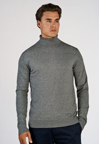 Grauer Rollkragenpullover mit taillierter Passform und gerippten Bündchen. Hergestellt aus strukturiertem Material, mit langen Ärmeln und hohem Kragen.
