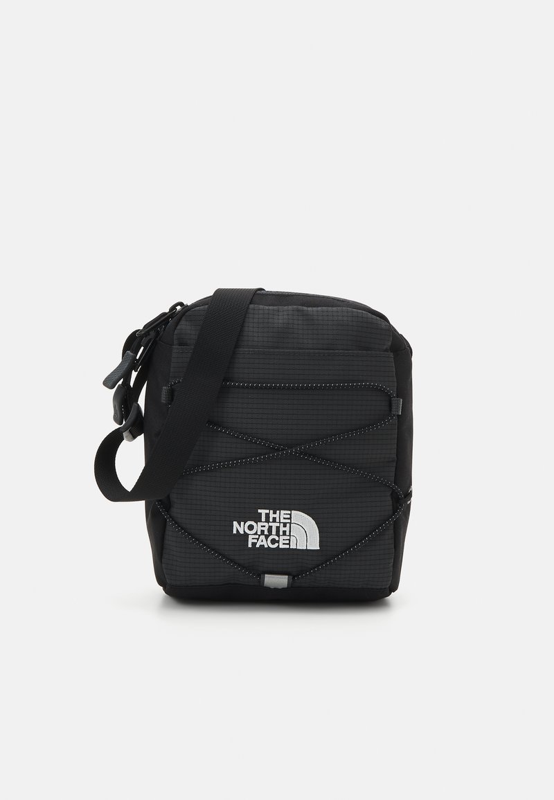 Borsa a tracolla nera con superficie testurizzata, caratterizzata da un logo bianco, tracolla regolabile e dettaglio elastico incrociato sulla parte frontale.