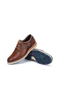 Brown leather shoes with a rounded toe, stitched detail, and orange laces. Feature a multi-color rubber outsole with a textured pattern.