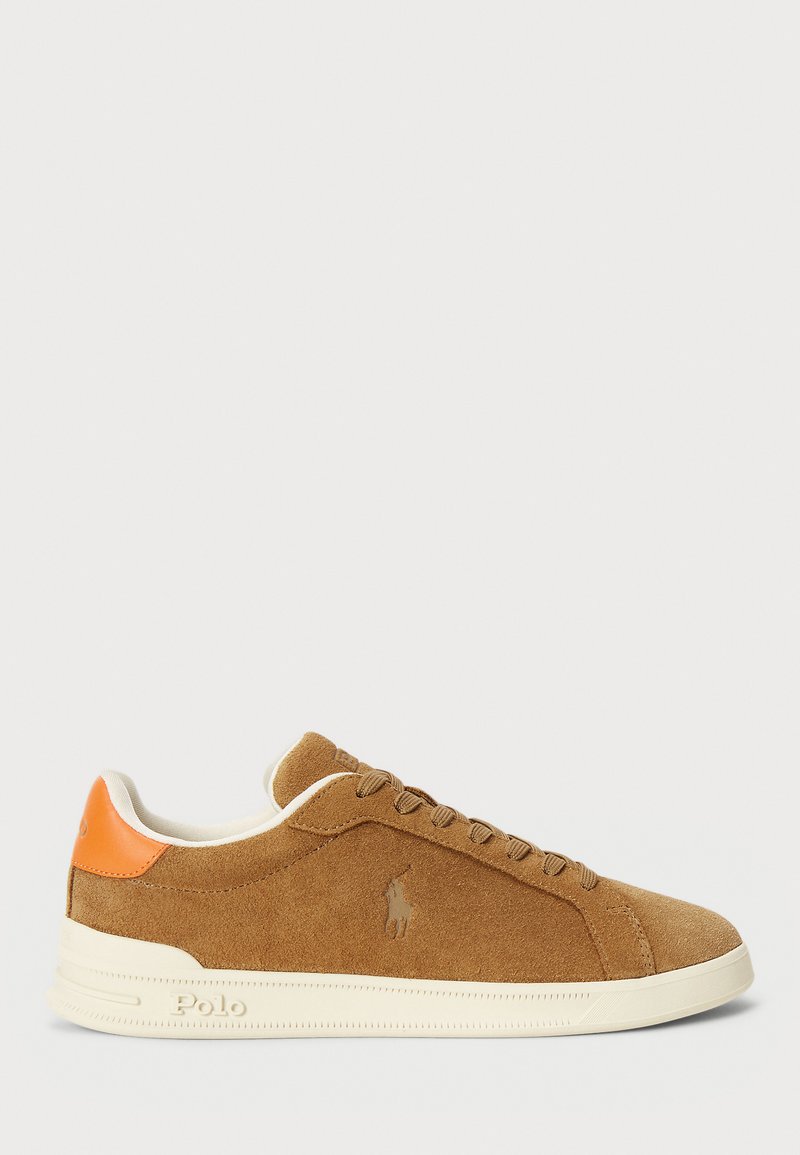 Brown suede sneaker with cream rubber sole, featuring a textured orange accent at the heel and tonal laces, embossed logo detail on the side.