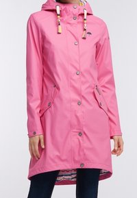 Cappotto impermeabile rosa con cappuccio, chiusura a bottoni, due tasche frontali con patta e cordoncini decorativi con perline e nappine.