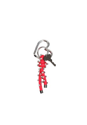 Llavero trenzado rojo con acentos decorativos plateados, sujeto a un mosquetón de acero inoxidable, con una llave negra.