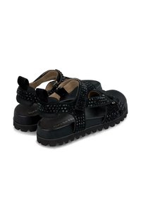 Sandalias de plataforma negras con correas ajustables, acentos texturizados con tachuelas y una suela robusta para mayor tracción. Forro suave para mayor comodidad.