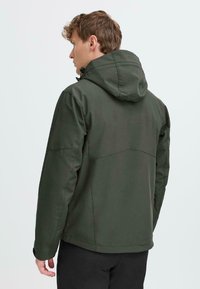 Veste à capuche vert foncé avec une finition lisse et mate. Présente un design ajusté et une capuche réglable. Couture renforcée aux coutures.