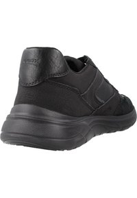 Sneaker nera con una combinazione di pelle texturizzata e tessuto. Tacco arrotondato, suola imbottita e dettagli di cucitura minimalisti.