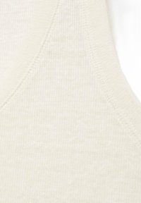 Cremefarvet ribbet tanktopstof med en glat tekstur og en buet halsudskæring. Syninger er synlige langs kanterne.