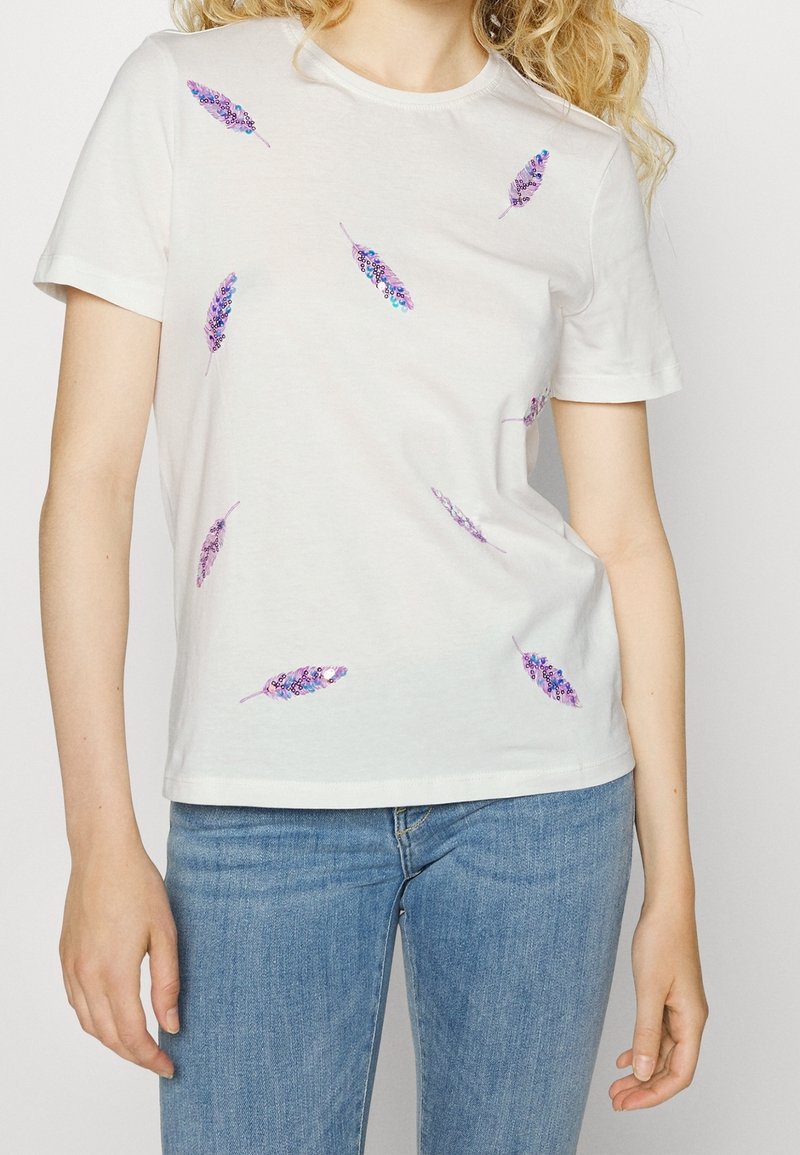 Hvid bomulds T-shirt med korte ærmer, prydet med lilla fjer-designs spredt over forsiden. Blød tekstur og klassisk rund hals.