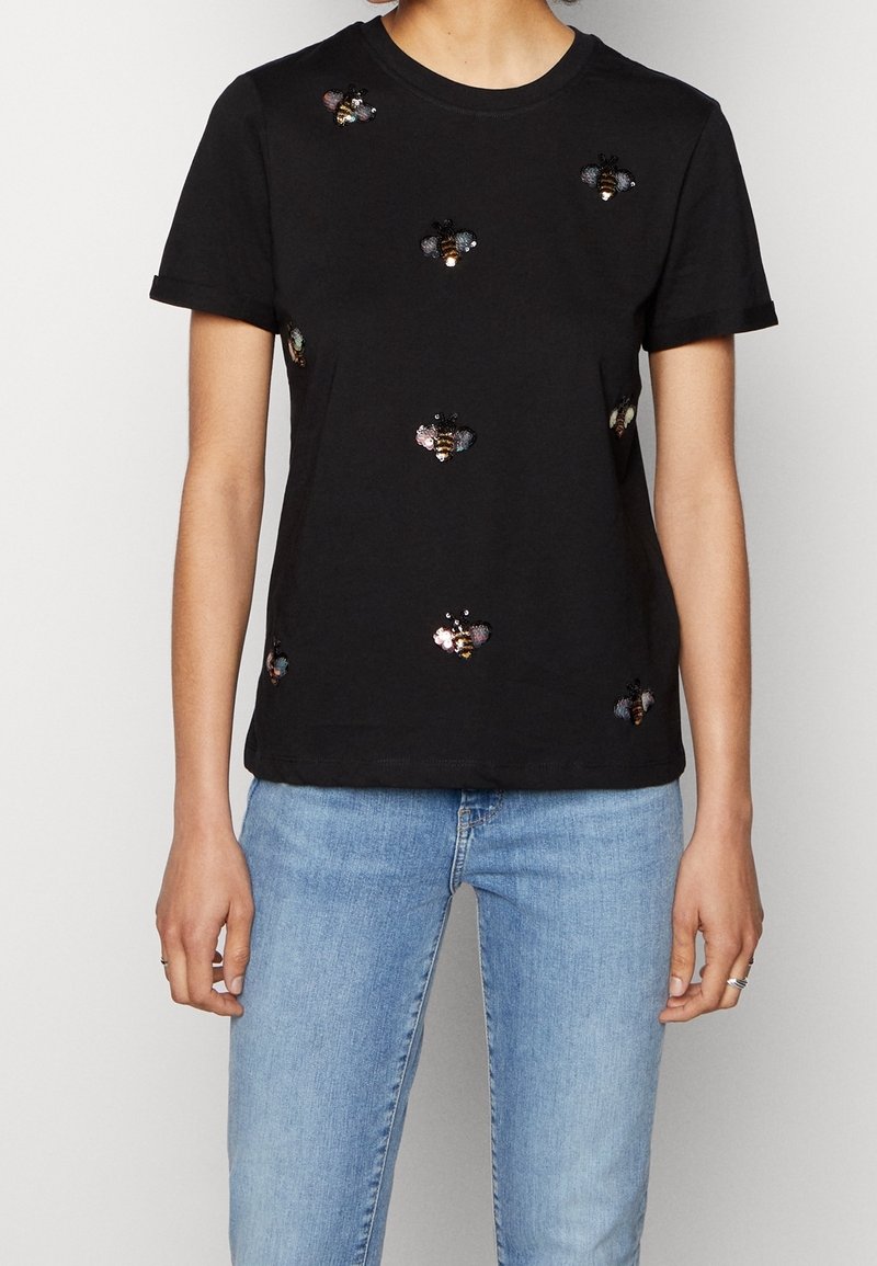 T-shirt en coton noir avec broderie d'abeilles colorées sur le devant. Manches courtes et col arrondi, avec une coupe régulière.