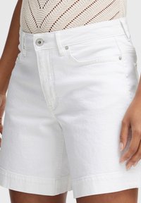 Shorts in denim bianco con un design classico a cinque tasche. Presentano una vita aderente, una linea dritta e orli risvoltati. Realizzati in tessuto di cotone testurizzato.