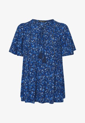 Kort mouwtje blauwe blouse met kleine bloemenprint, ronde halslijn en touwtje met kwastjes aan de voorkant.