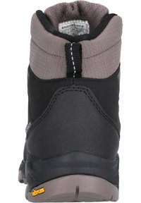 Botte de randonnée noire avec un col rembourré gris, une tige synthétique texturée et une semelle extérieure Vibram pour une meilleure traction. Étiquette visible à l'intérieur de la botte.