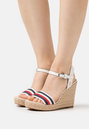 Sandali wedge bianchi con suola in juta, due cinturini intrecciati con strisce rosse e blu navy, e una cinghia alla caviglia con fibbia.