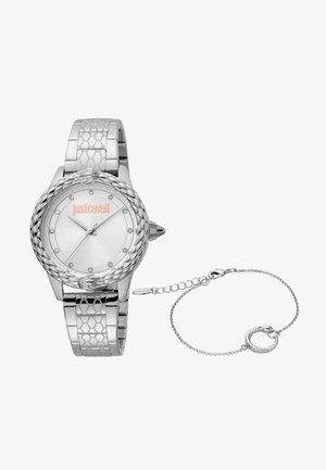 Strieborné hodinky s okrúhlym ciferníkom, textúrovaným remienkom a jemnými akcentmi z drahokamov. Obsahujú zodpovedajúci strieborný náramok so vzorom hada.