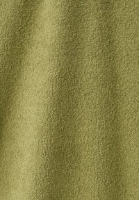 Gros plan sur un tissu en éponge vert olive avec une surface texturée et bouclée et des plis doux.