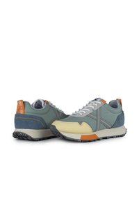 Zapatillas que presentan una combinación de cuero azul y gris claro, puntera amarilla, acentos naranjas y una suela de goma texturizada con patrón de relieve visible.