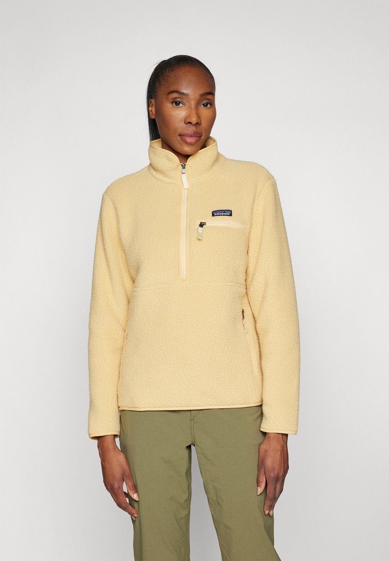 Fleece pullover in lichtgeel met een hoge kraag, halve rits en een borstzak; zachte textuur en rechte pasvorm.
